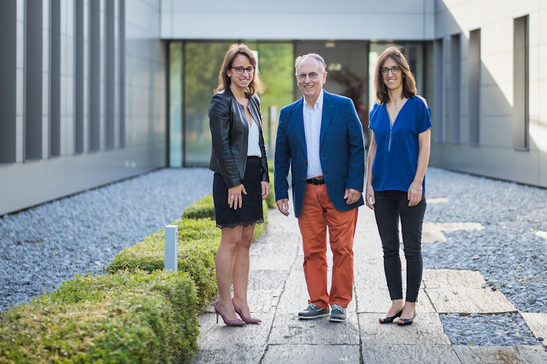 Trois dirigeants d'entreprise devant leur siège social