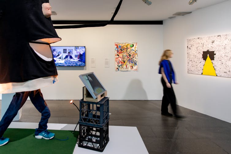 A woman walks through a gallery.