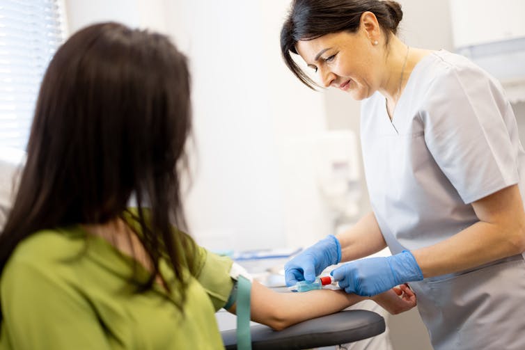 A female nurse gives a woman a blood test.