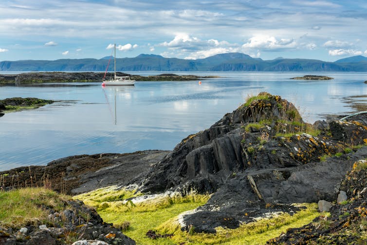 rocky coastline of Slate Islands in Scotl;and with calm seas