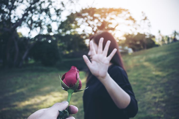 Woman rejecting a rose