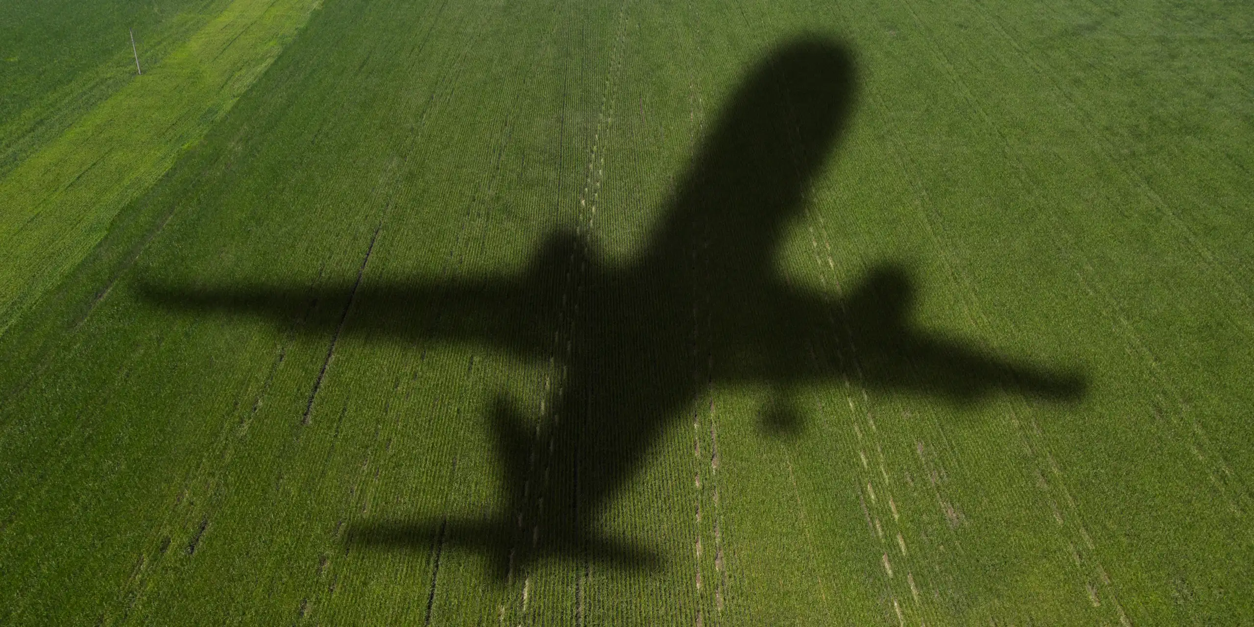 shadow of airplane on green field