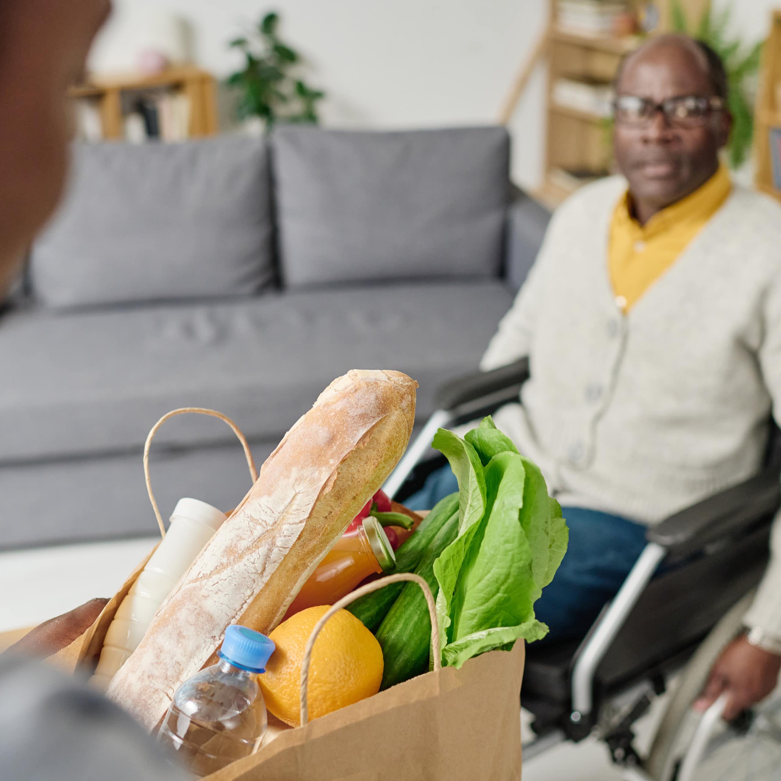 Une femme fait les courses pour son proche en situation de handicap qui se déplace en fauteuil roulant