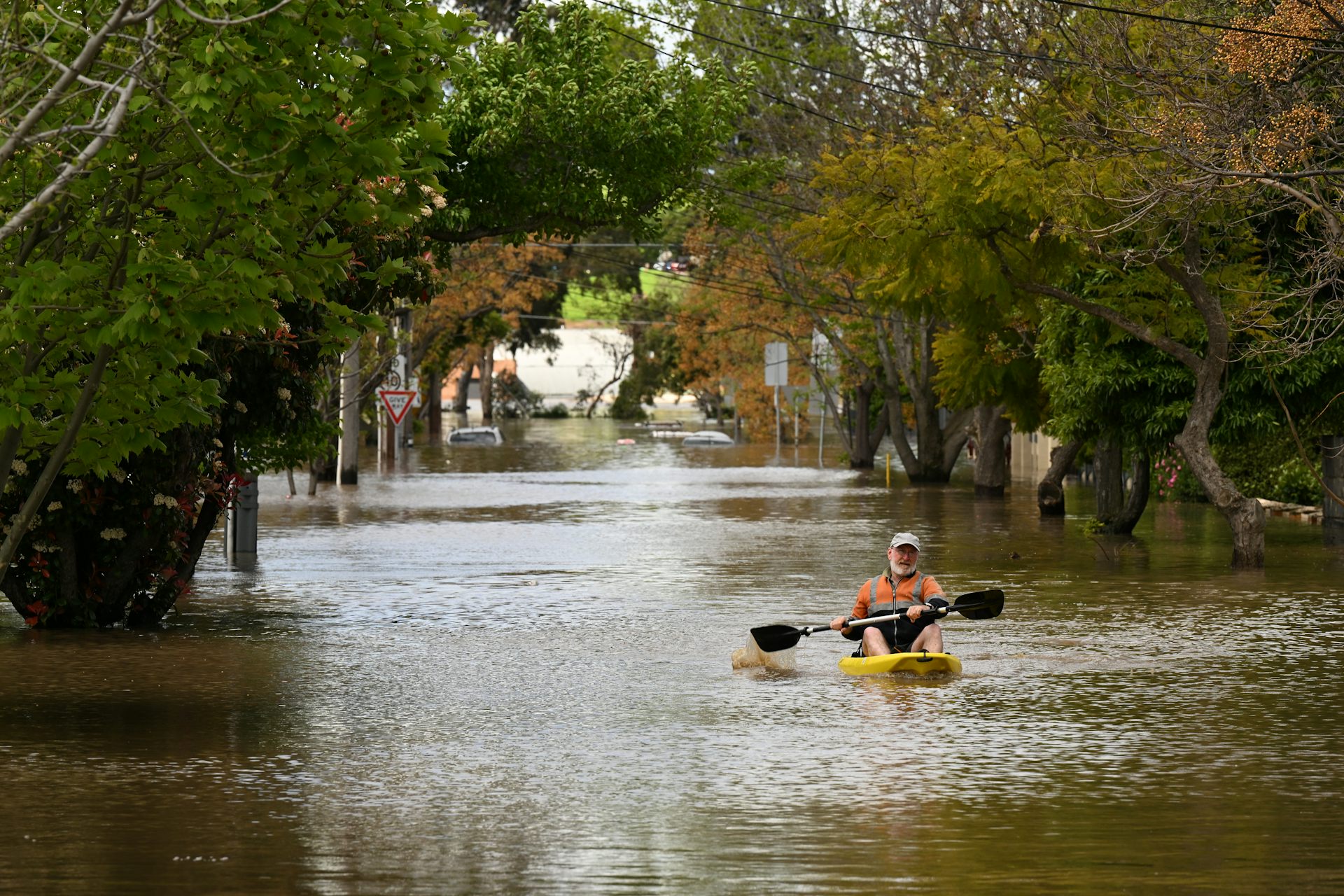 A man is seen canoeing along flood waters in Maribyrnong, Melbourne, Friday, October 14, 2022.