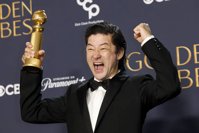 A very excited man holds his award.