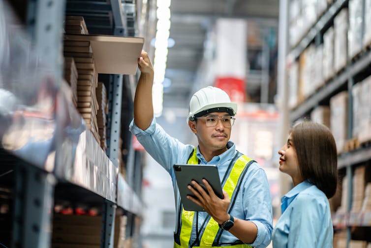 Warehouse staff working together using digital tablets to check the stock inventory