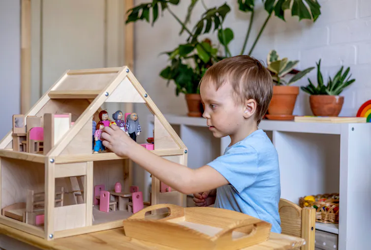 Boy playing with dollhouse