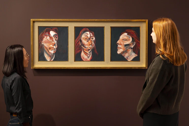 Three Studies for Portrait of Isabel Rawsthorne on the wall of a gallery, with two women looking on.