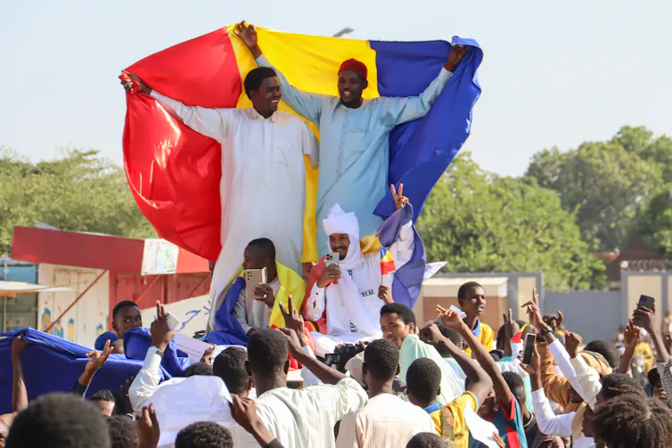A crowd of Chadians holding flags as they protest.