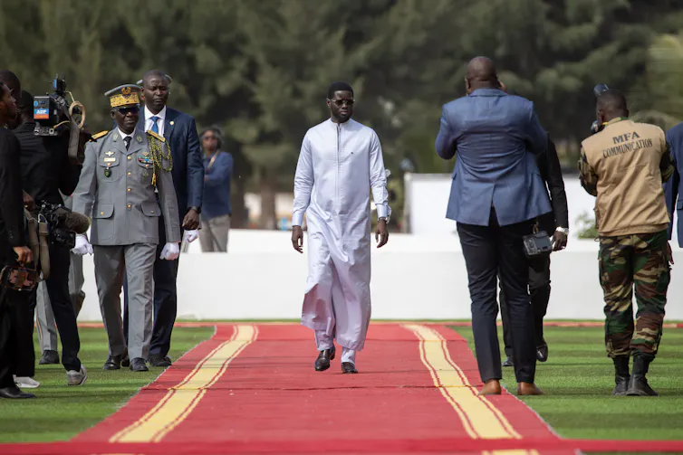 Senegal's president, Bassirou Diomaye Faye, walks down a red carpet.