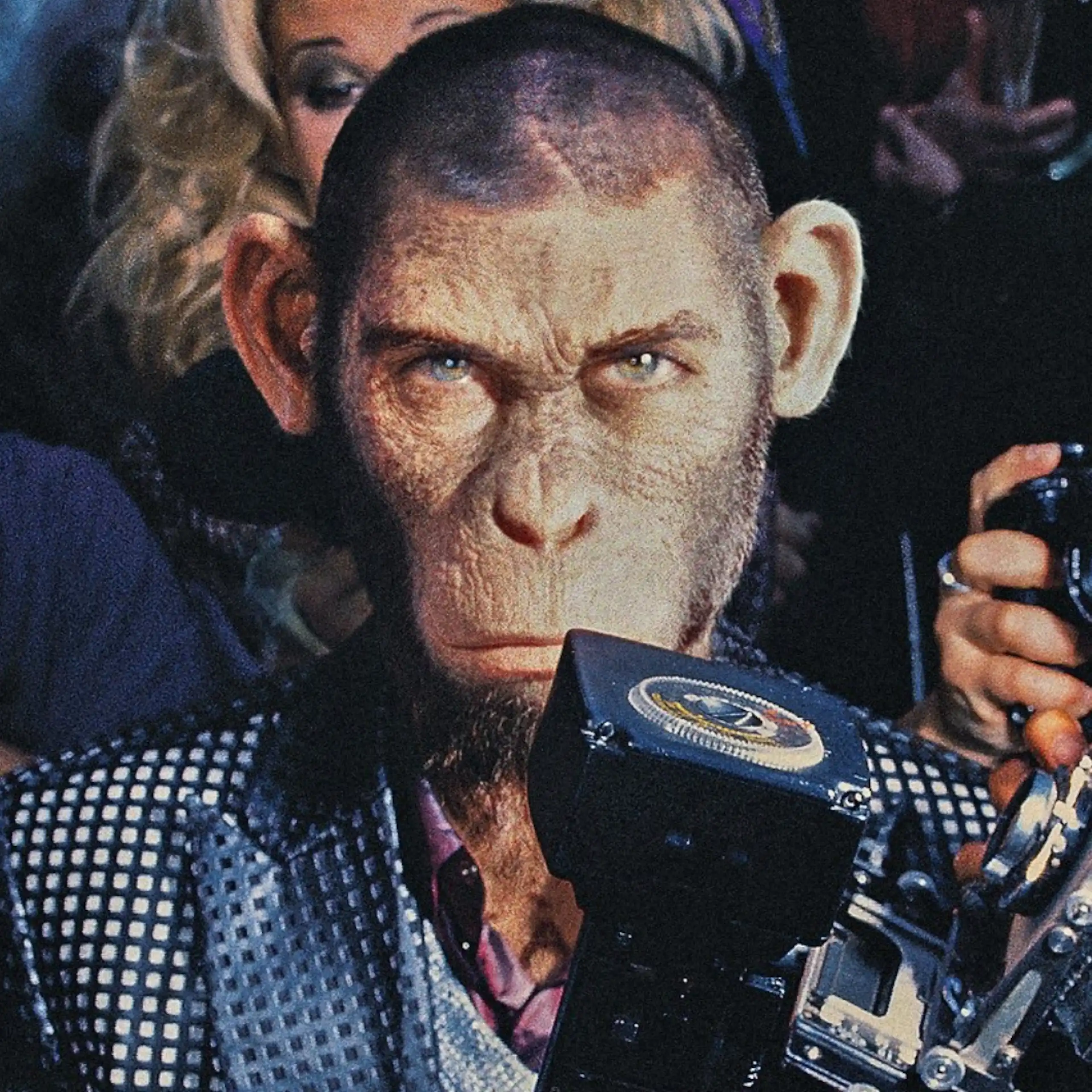A chimpanzee dressed as a human pop star staring at the camera