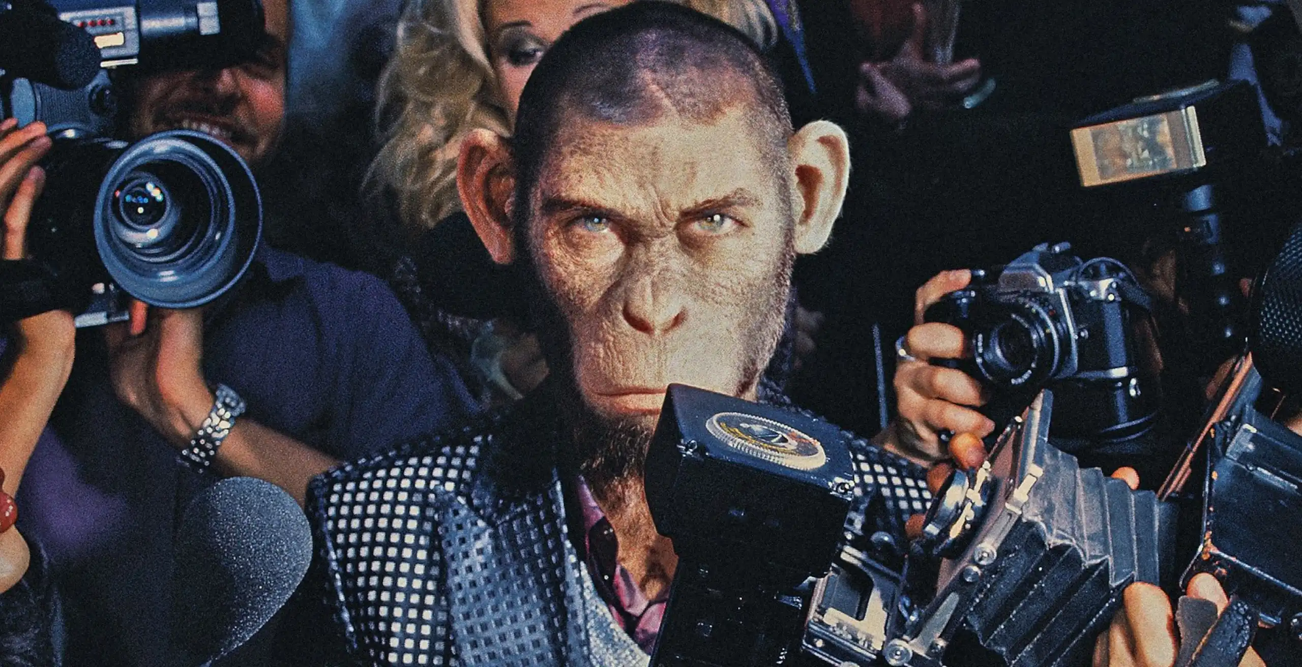 A chimpanzee dressed as a human pop star staring at the camera