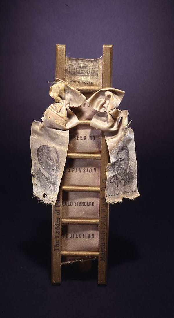 A miniature ladder with a ribbon that features the likenesses of President William McKinley and his new vice president, Theodore Roosevelt.