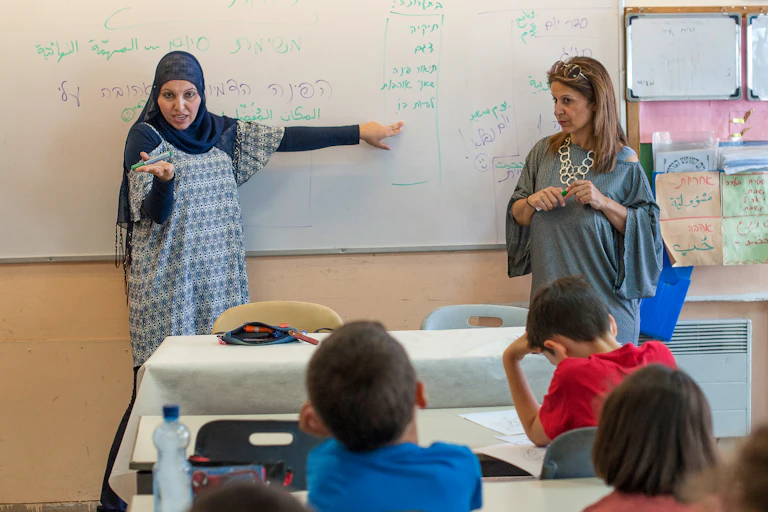 Two teachers instruct third grade students.