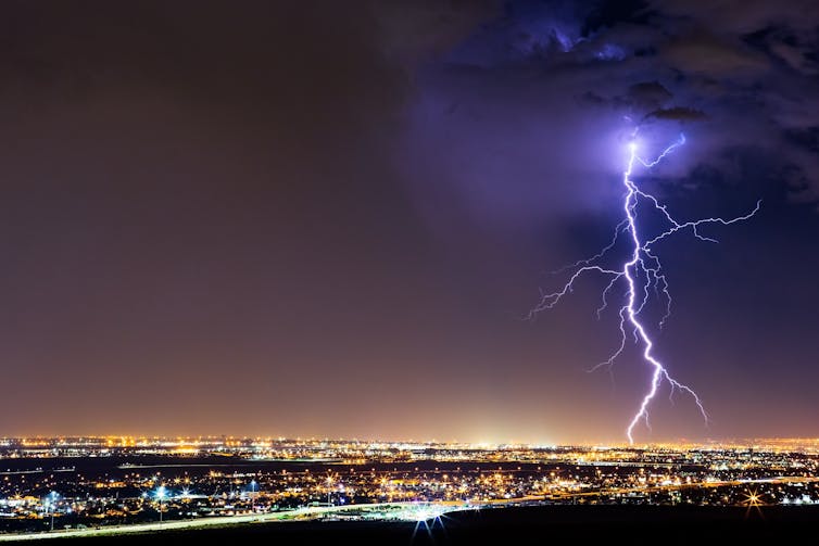 A bolt of lightning striking above a city skyline.