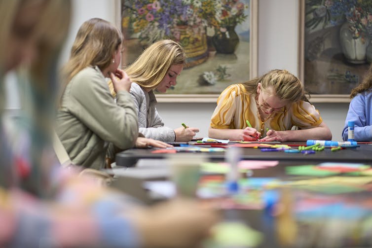 Teenagers drawing in an art gallery.