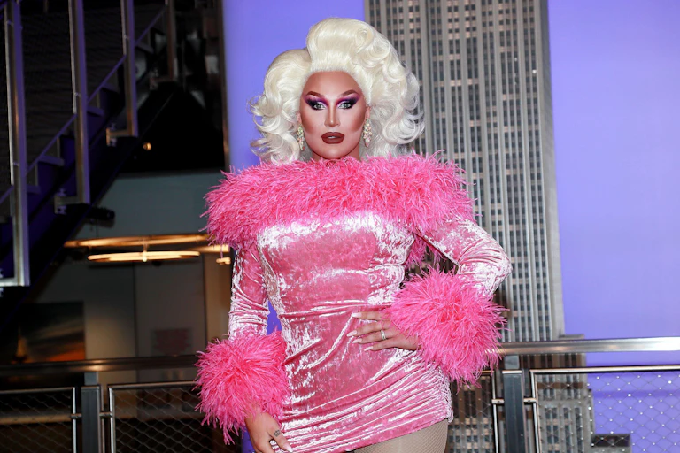 The Vivienne in a blonde wig and pink fluffy dress