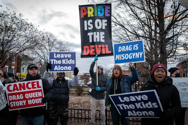 Protestors holding anti-drag signs