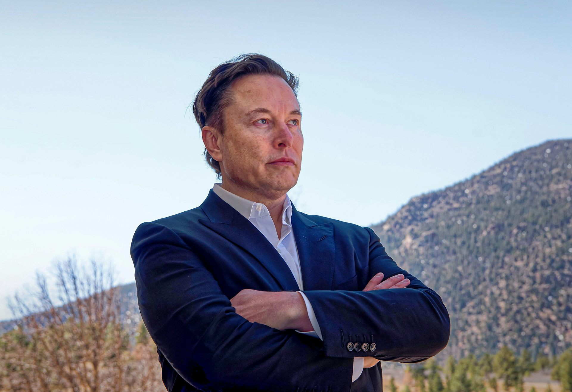 Elon Musk with his arms crossed.