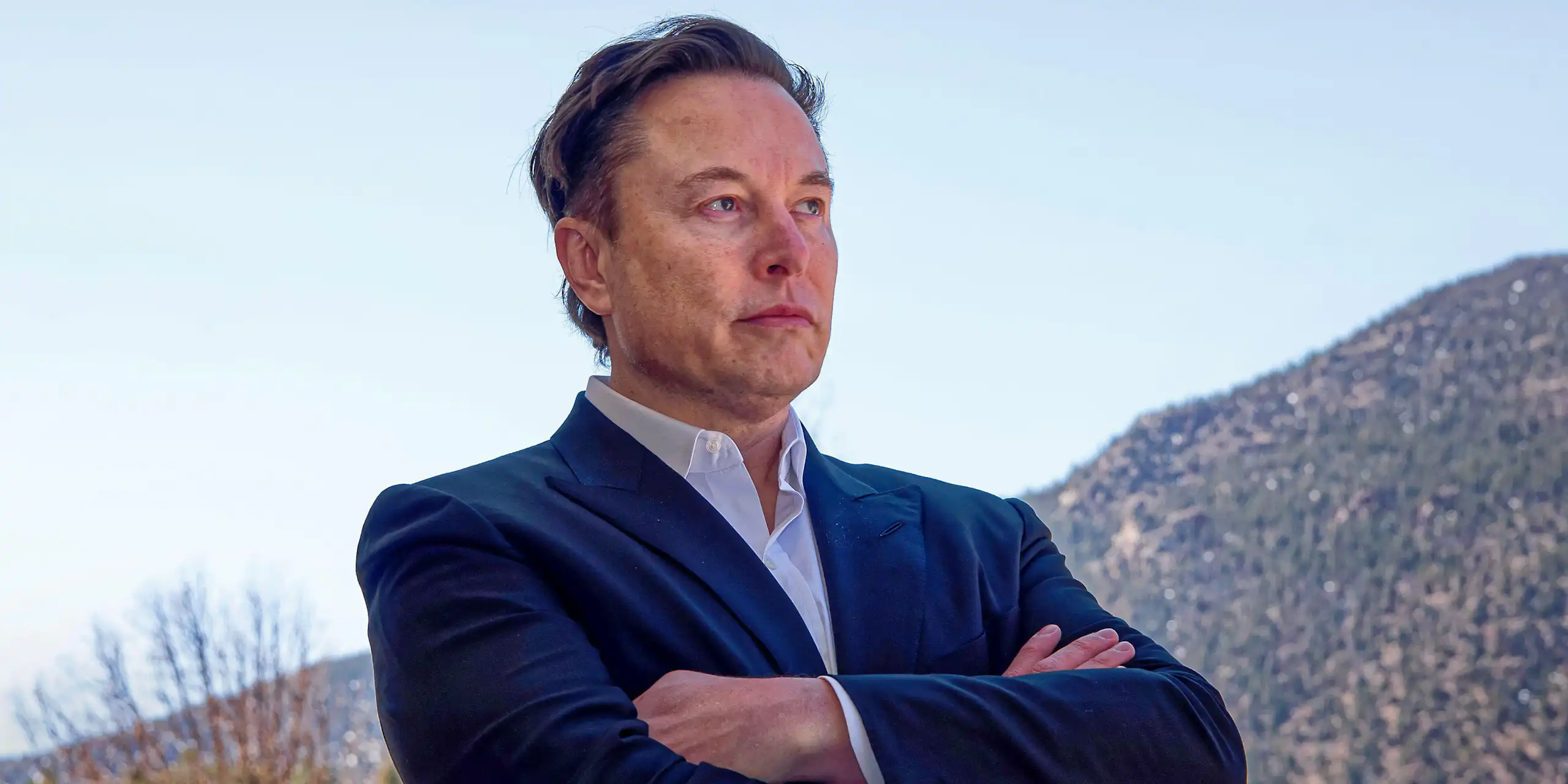 Elon Musk with his arms crossed.