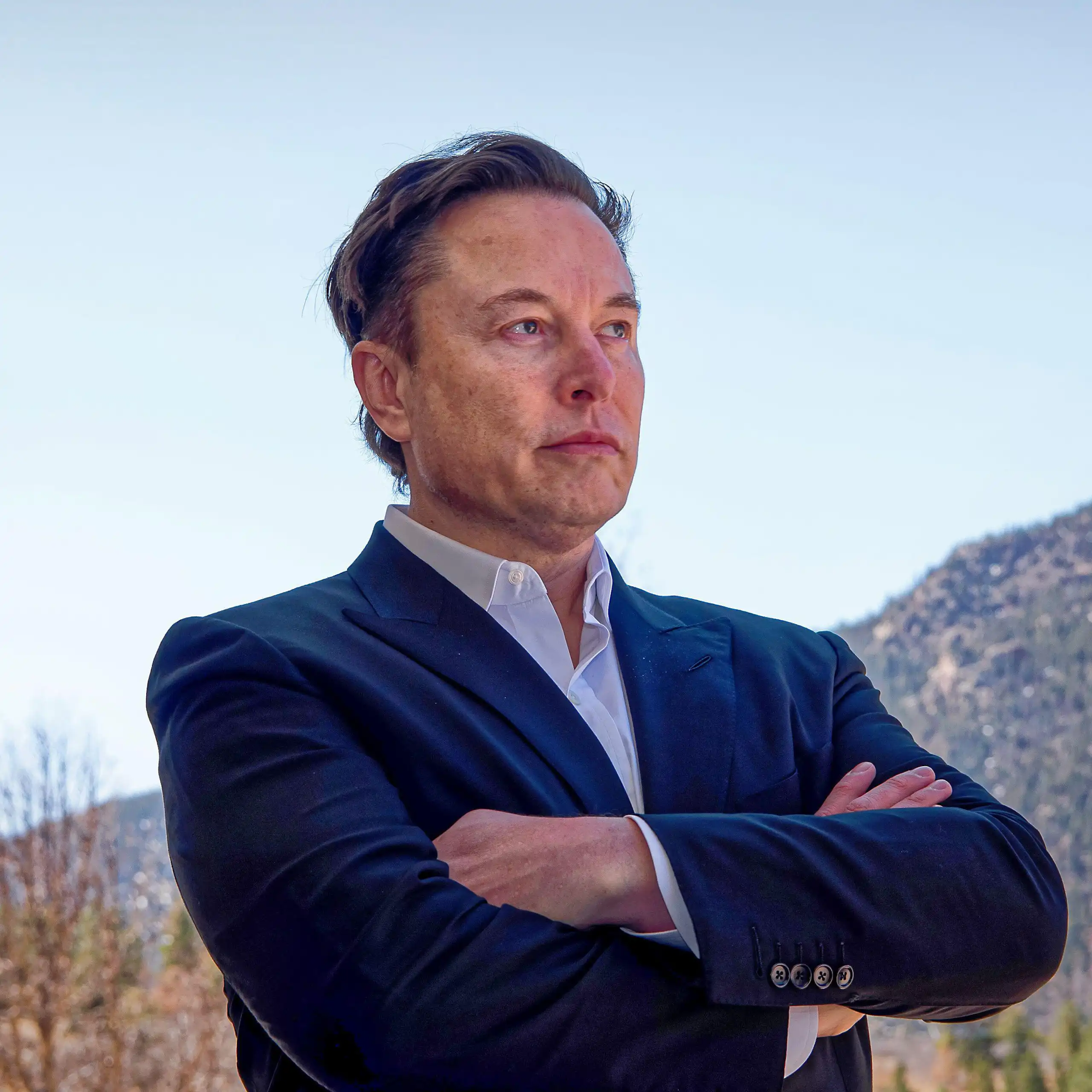 Elon Musk with his arms crossed.
