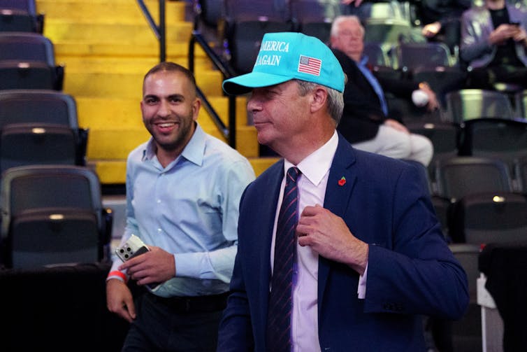 Nigel Farage wearing a MAGA hat.