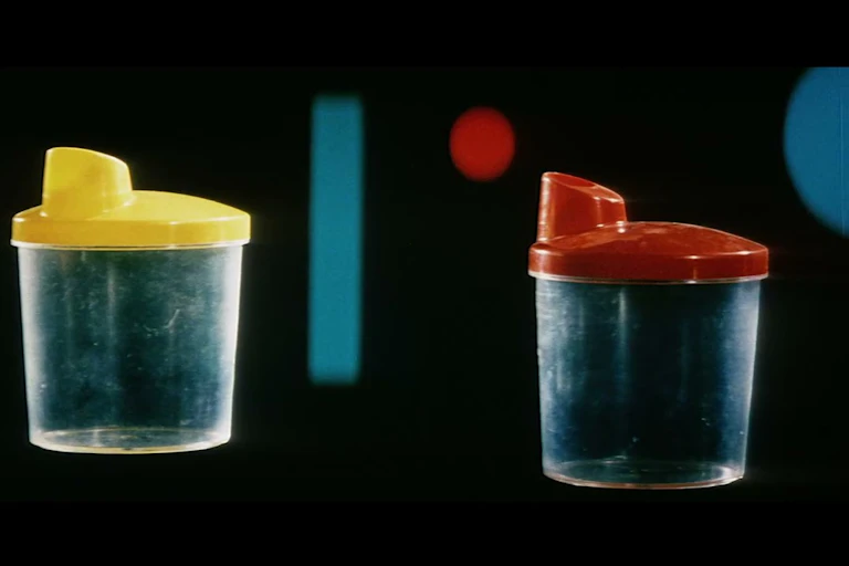 Photogramme du Chant du styrène : verres dotés de capuchons en plastique colorés
