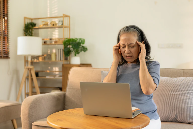 Une femme devant un ordinateur au téléphone qui semble "se prendre la tête"