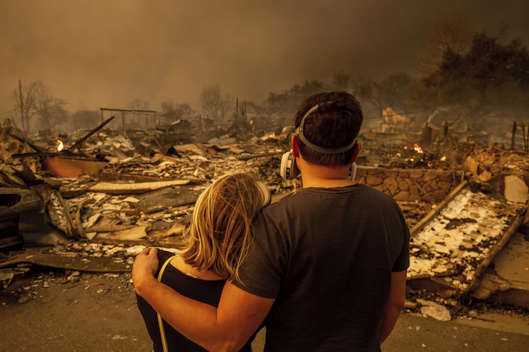 Megan Mantia, à gauche, et son petit-ami devant les ruines de leur maison après le passage de l'incendie, Californie.