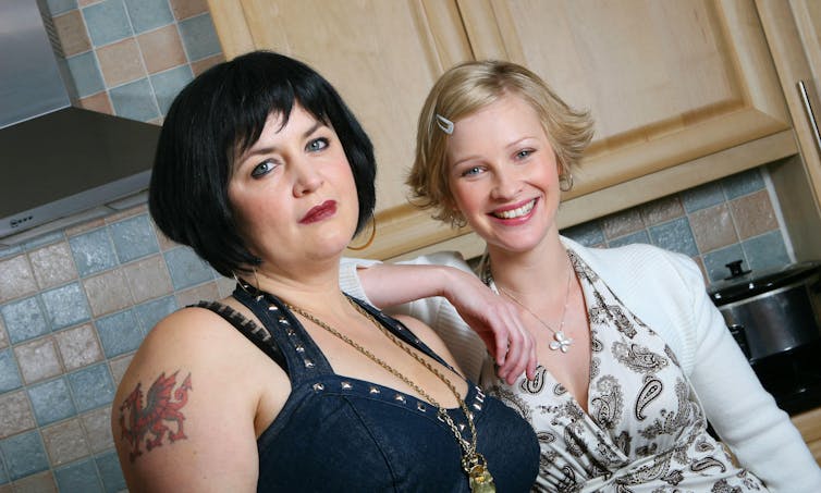 Nessa e Stacey estão lado a lado na cozinha.