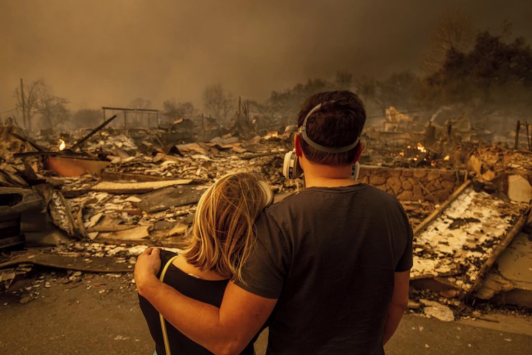 Megan Mantia, a la izquierda, y su novio Thomas, regresan a la casa de Mantia dañada por el fuego después de que el incendio de Eaton arrasara la zona, el miércoles 8 de enero de 2025 en Altadena, California.