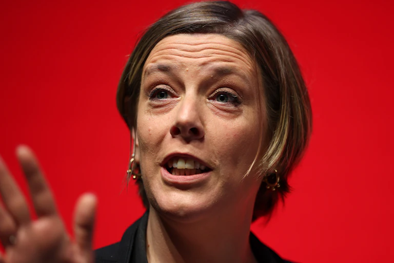 Close up of Phillips speaking, a red background behind her