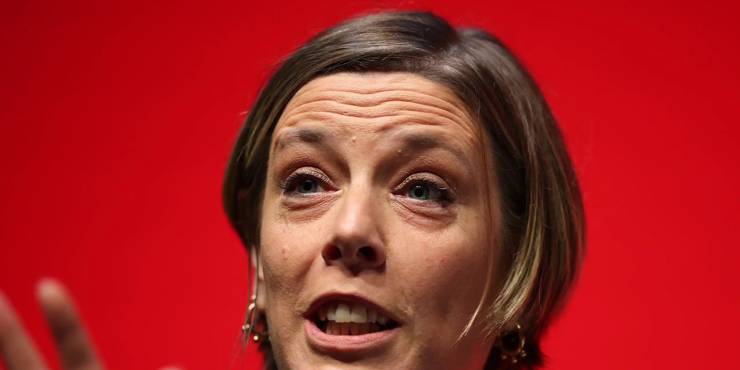 Close up of Phillips speaking, a red background behind her