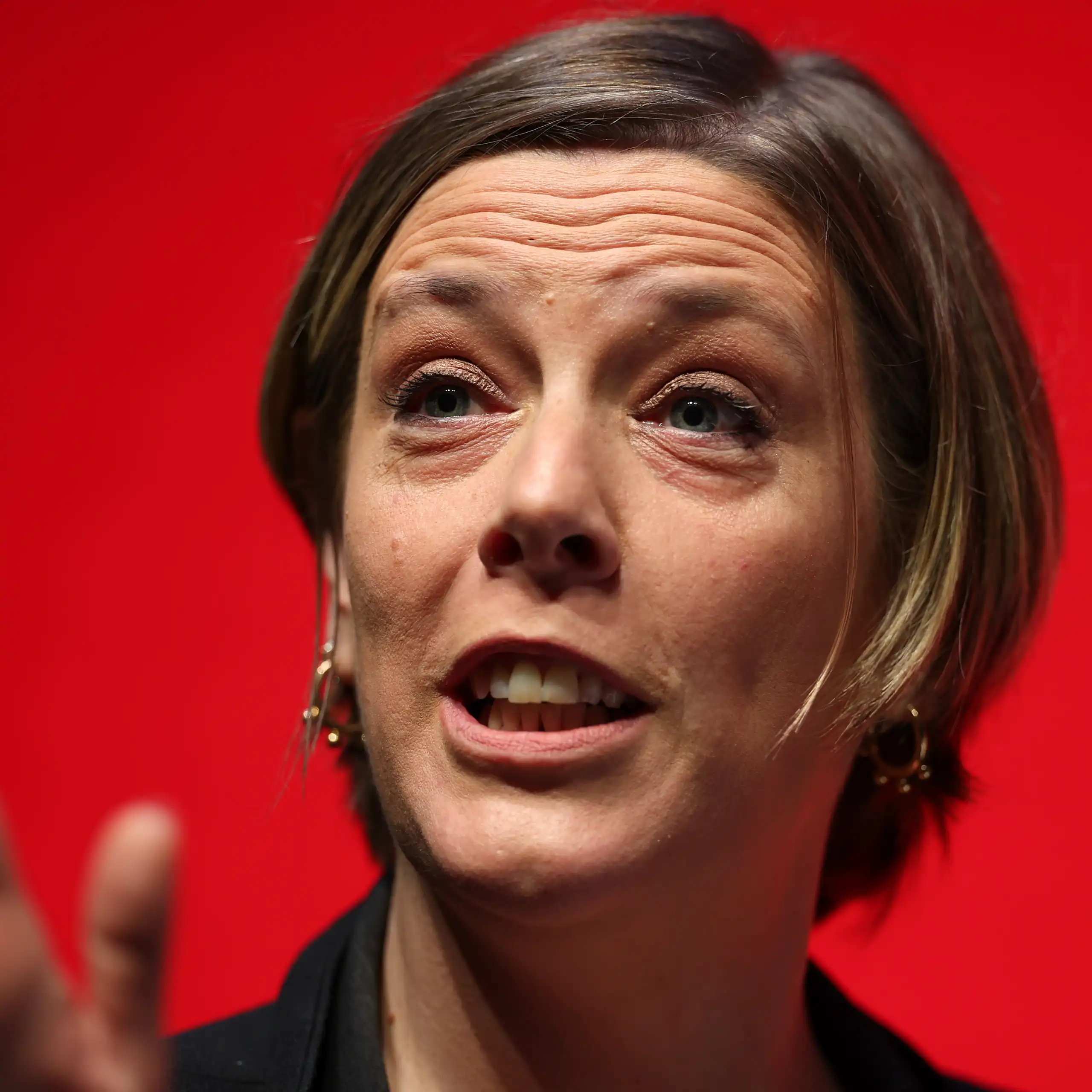Close up of Phillips speaking, a red background behind her