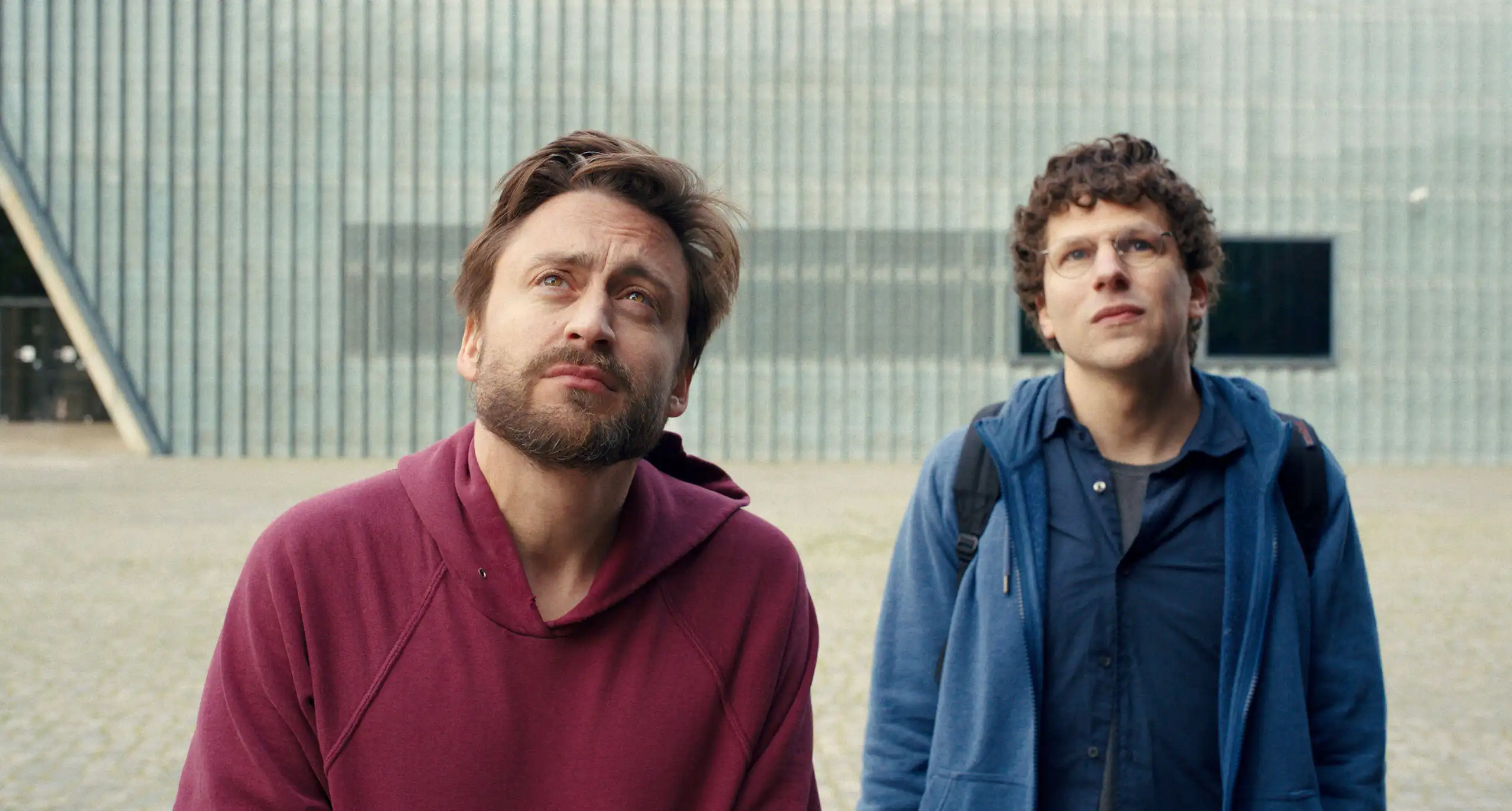 Kieran Culkin and Jesse Eisenberg looking to the sky