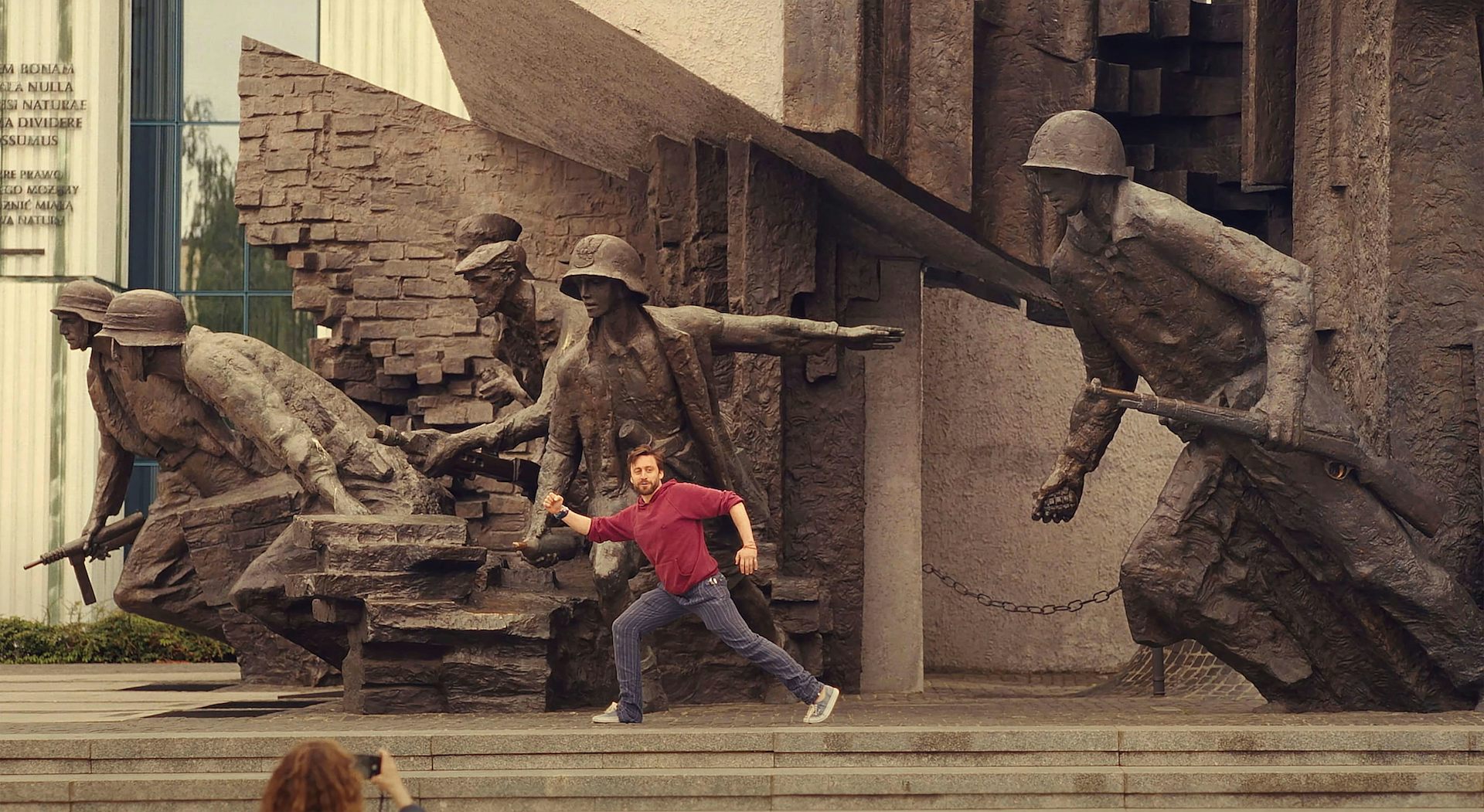 Benji posing with a large sculpture of soldiers