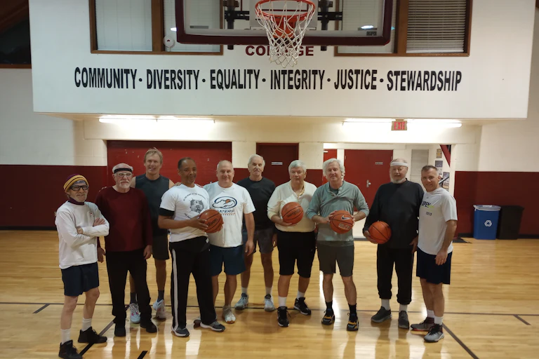Several players pose on a basketball court.