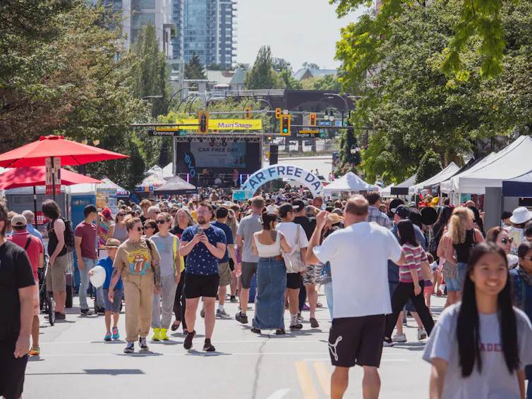 People stroll a city street on a sunny day.