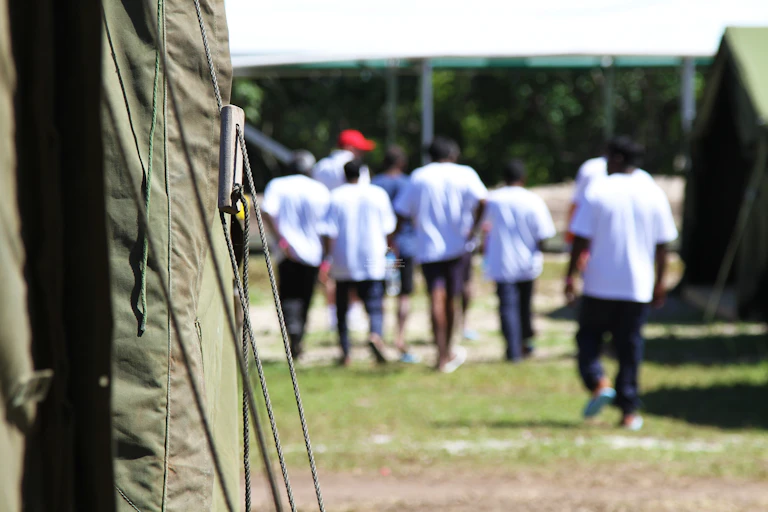 A group of men walk away from a tent