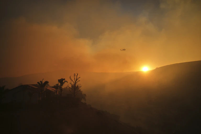 sun sets over smoky landscape