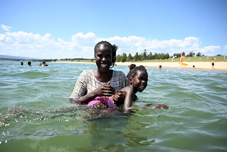 a woman and her daughter smiling in the water