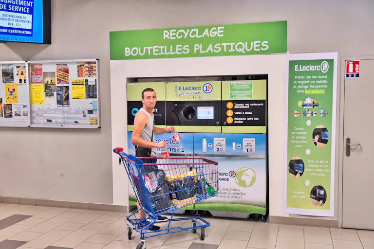 Homme recyclant ses déchets dans un supermarché