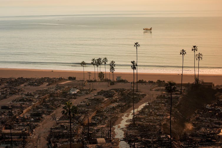 Remains of burned houses with sea in background
