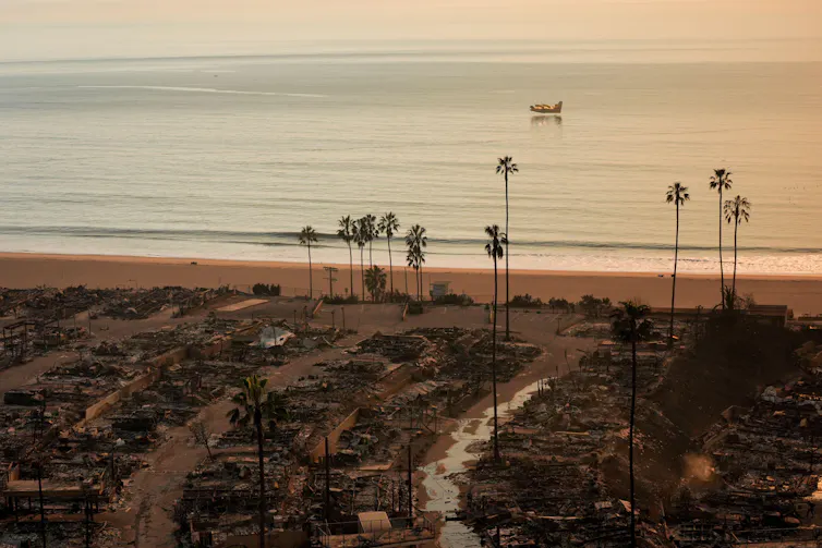 Remains of burned houses with sea in background
