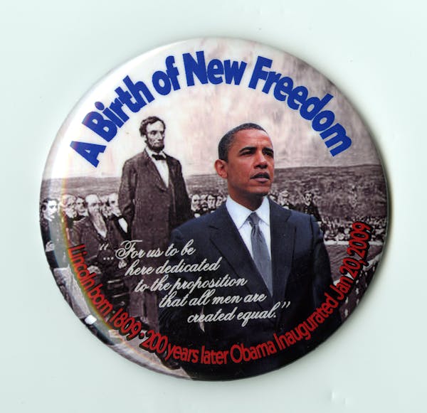 A button with images of Abraham Lincoln and Barack Obama on it, with 'A Birth of New Freedom' printed above those images.
