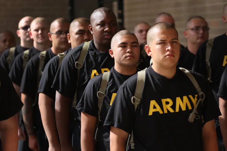 People stand in rows wearing shirts that say 'Army.'