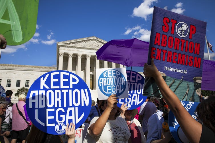 Protesers outside the Supreme Court building hold signs supporting abortion rights