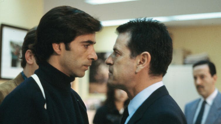 Dos hombres cara a cara en lo que parece ser mitad de una discusión.