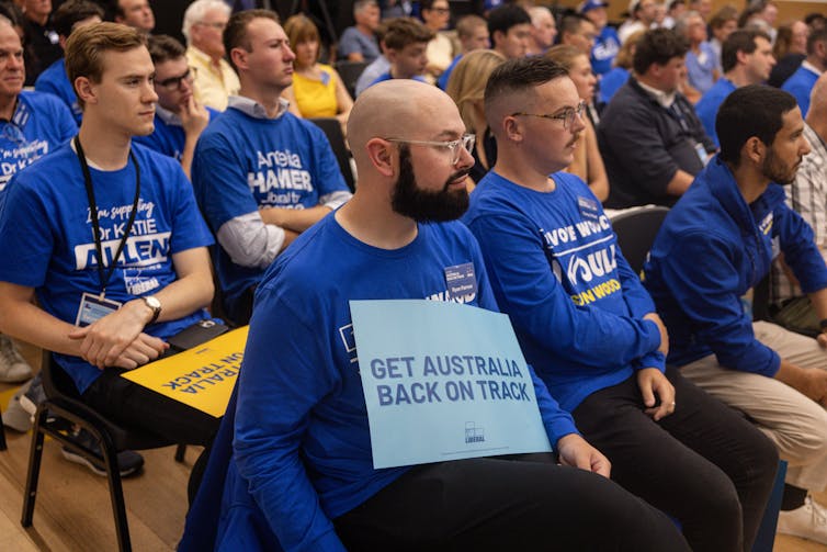 A group of people wearing matching blue political t-shirts