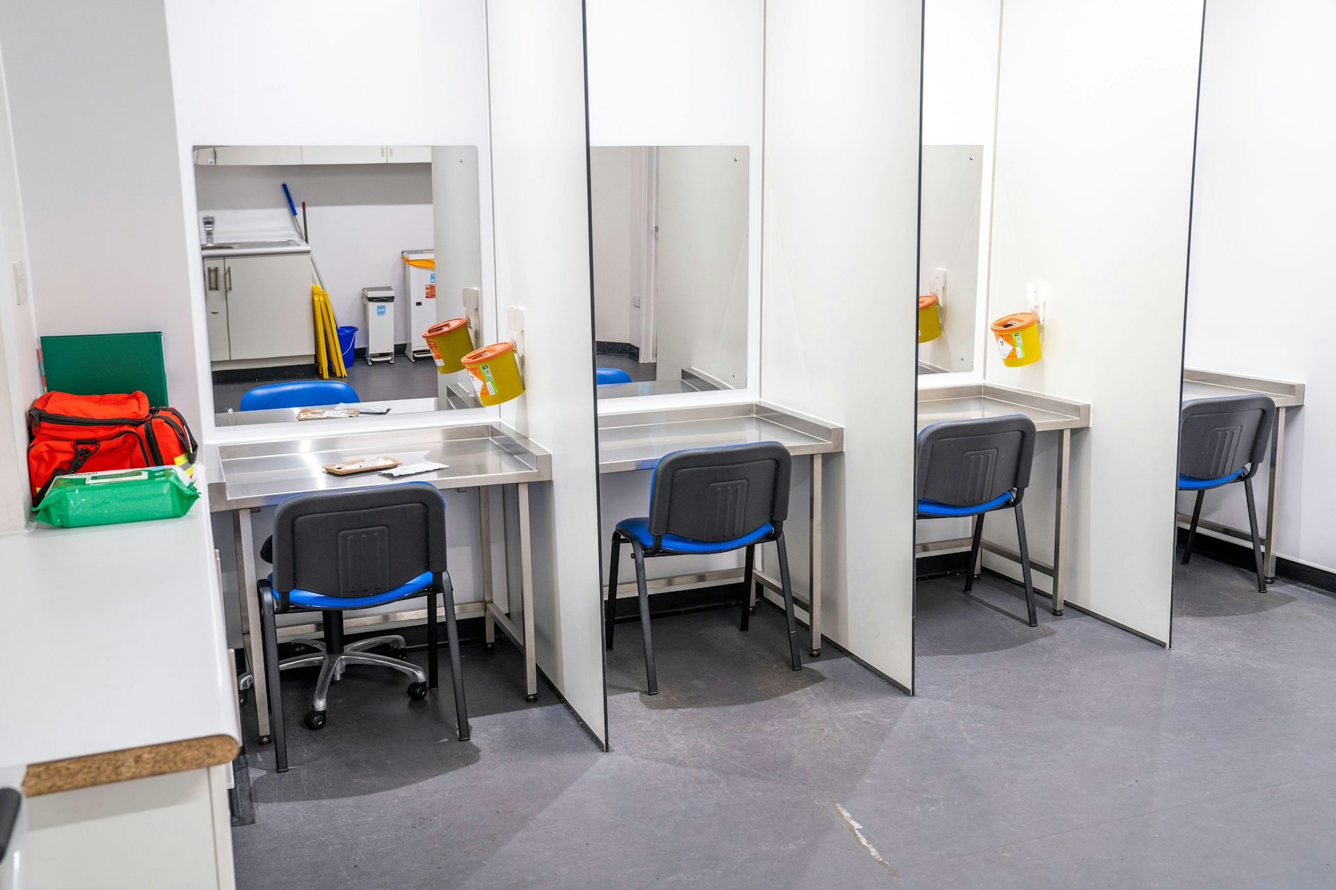 Drug consumption room with chairs and sharps bins.
